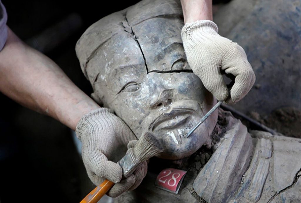 Archaeological experts are carefully cleaning the mud off the faces of the terracotta warriors